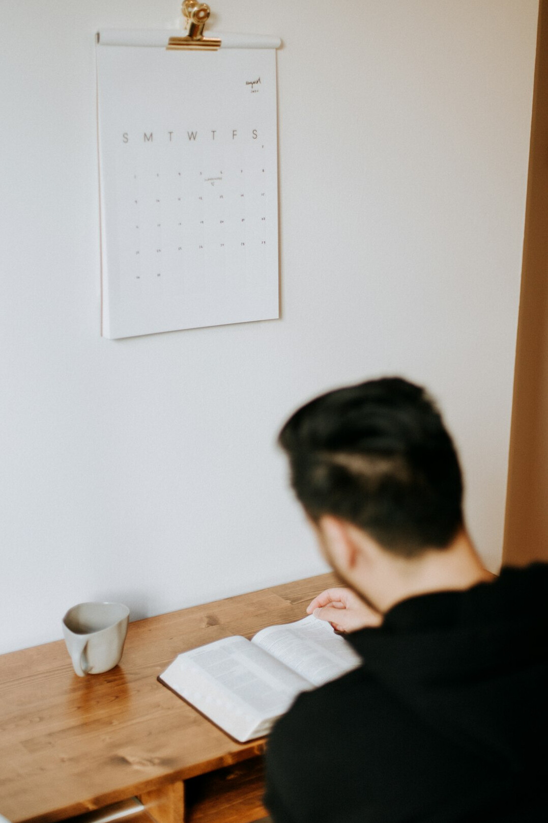 man reading book at desk